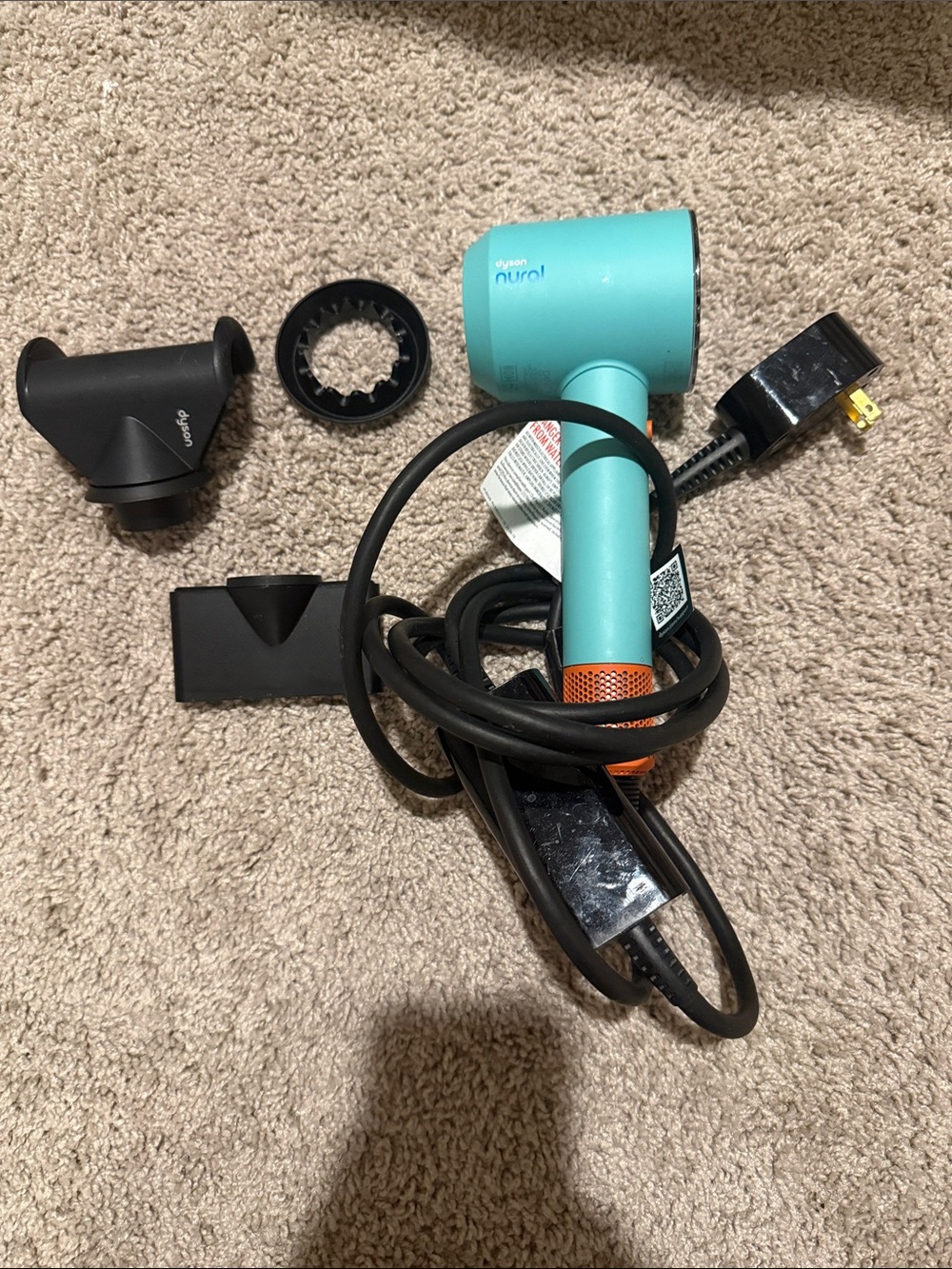 Dyson hair dryer in teal with orange and black accents